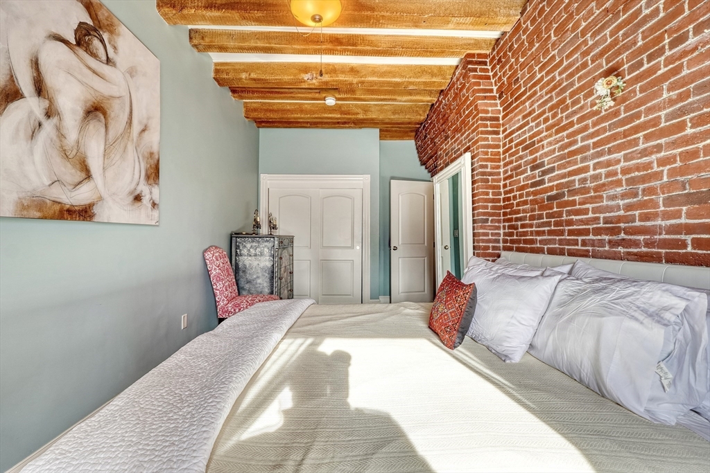 28-32 Atlantic Avenue, Unit 424 Boston, MA 02110 - Photo 25 of 38 a bedroom with a bed and a painting on the wall