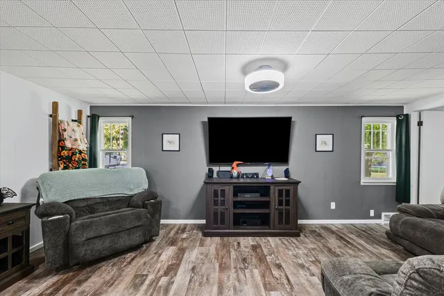 a view of a hallway with wooden floor and a ceiling fan