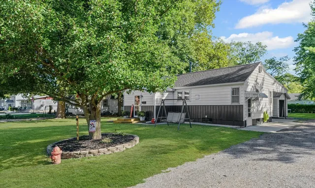 a front view of a house with garden and trees