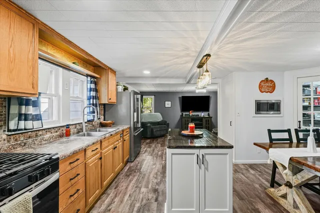 a kitchen with stainless steel appliances a refrigerator sink and white cabinets