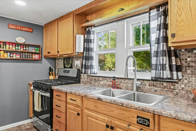 a kitchen with stainless steel appliances a stove refrigerator sink and cabinets