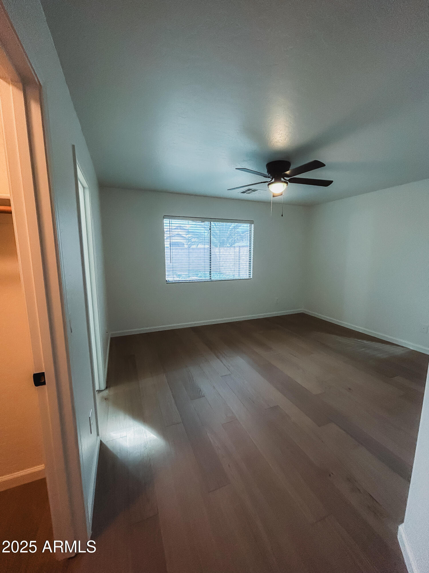 14857 West Hearn Road Surprise, AZ 85379 - Photo 13 of 20 an empty room with wooden floor and windows
