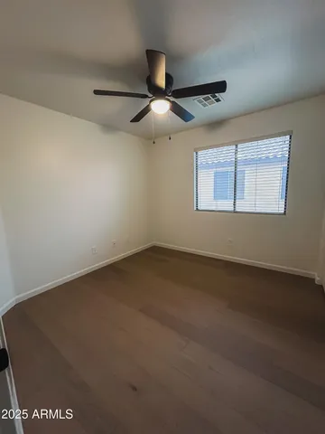 an empty room with a ceiling fan and a window