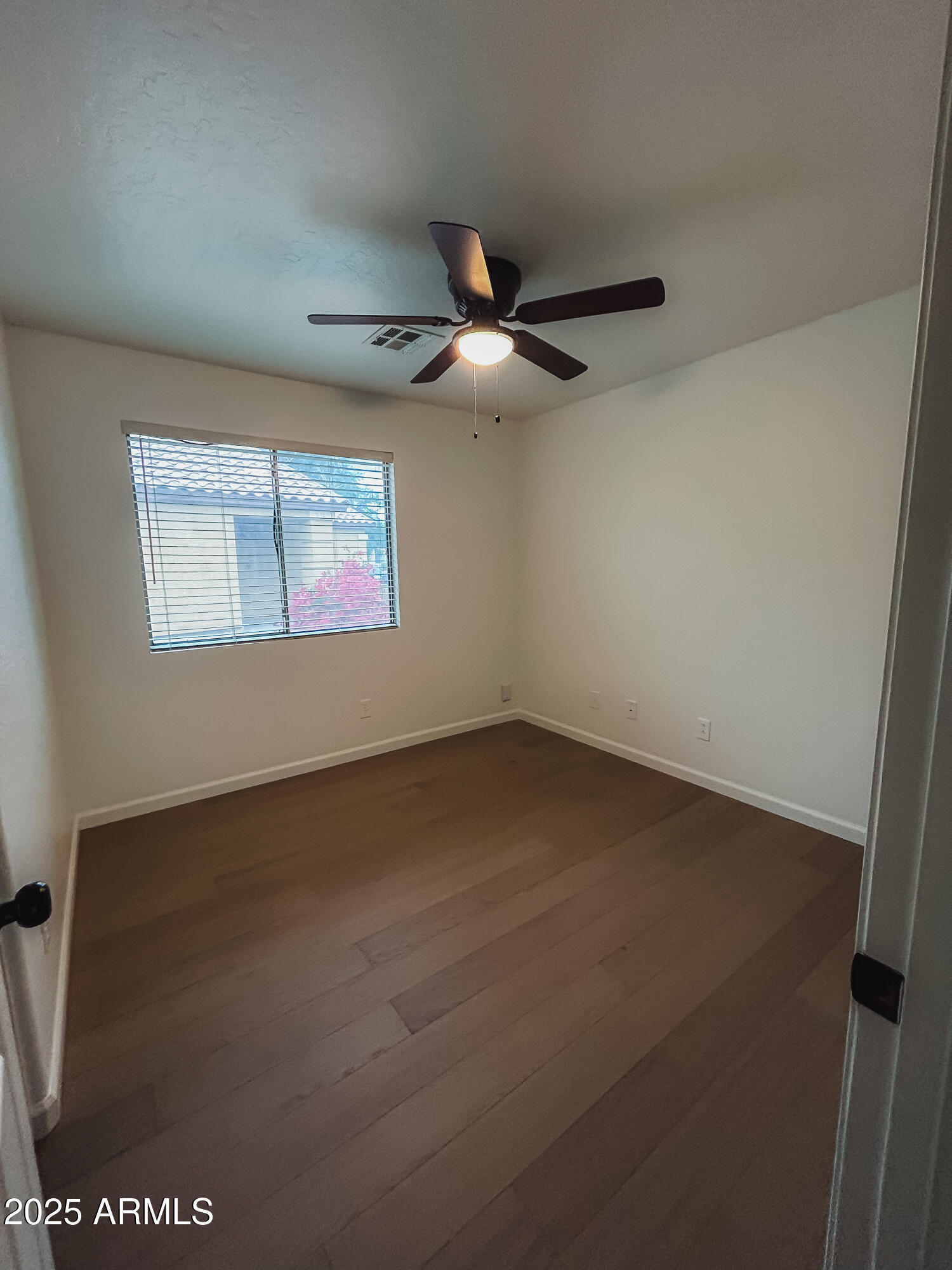 14857 West Hearn Road Surprise, AZ 85379 - Photo 18 of 20 an empty room with a ceiling fan and a window