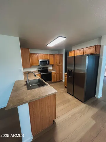 a kitchen with stainless steel appliances granite countertop a refrigerator a stove and a sink