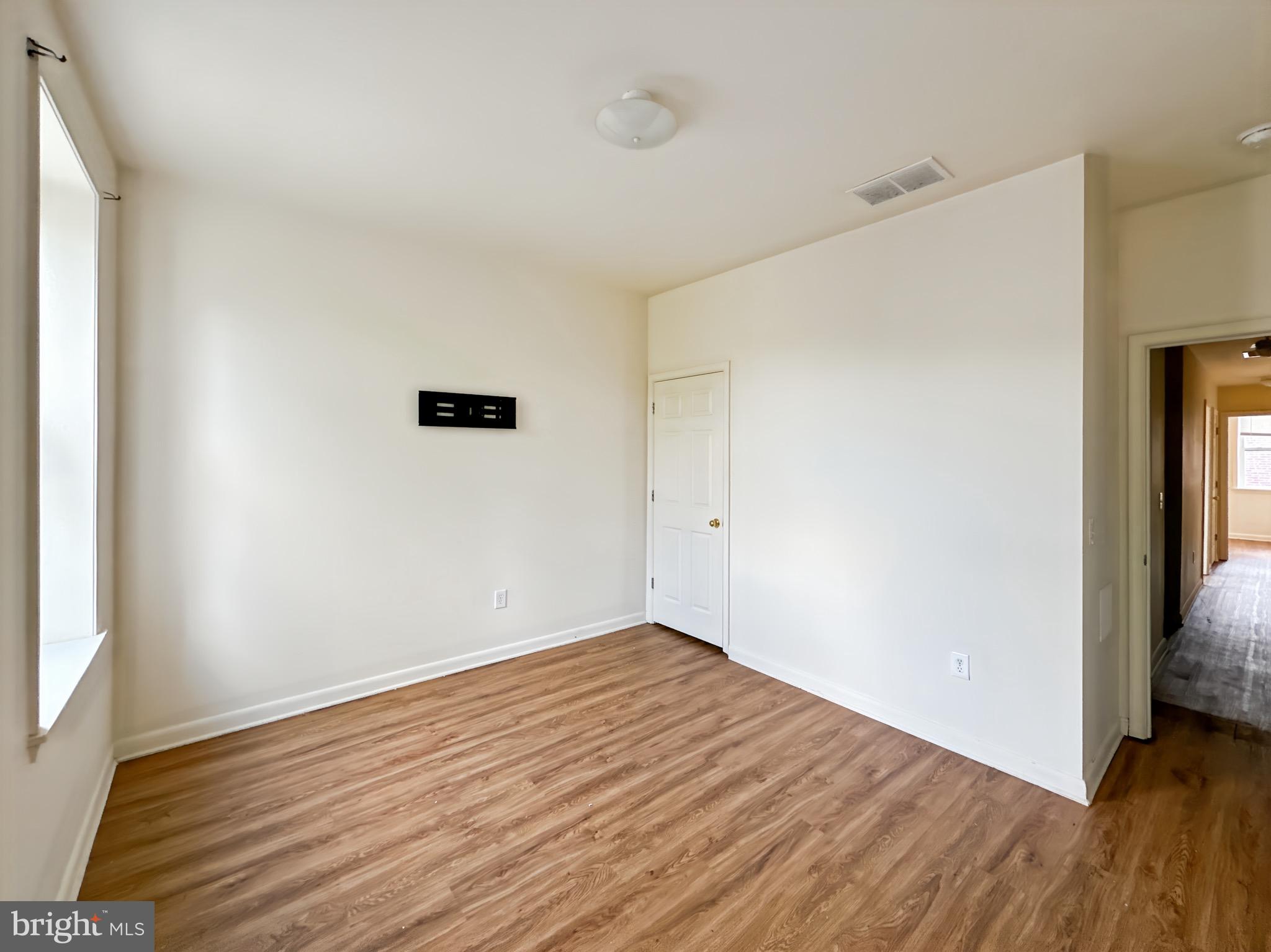 2426 Jefferson Street Baltimore, MD 21205 - Photo 12 of 17 an empty room with wooden floor and a window