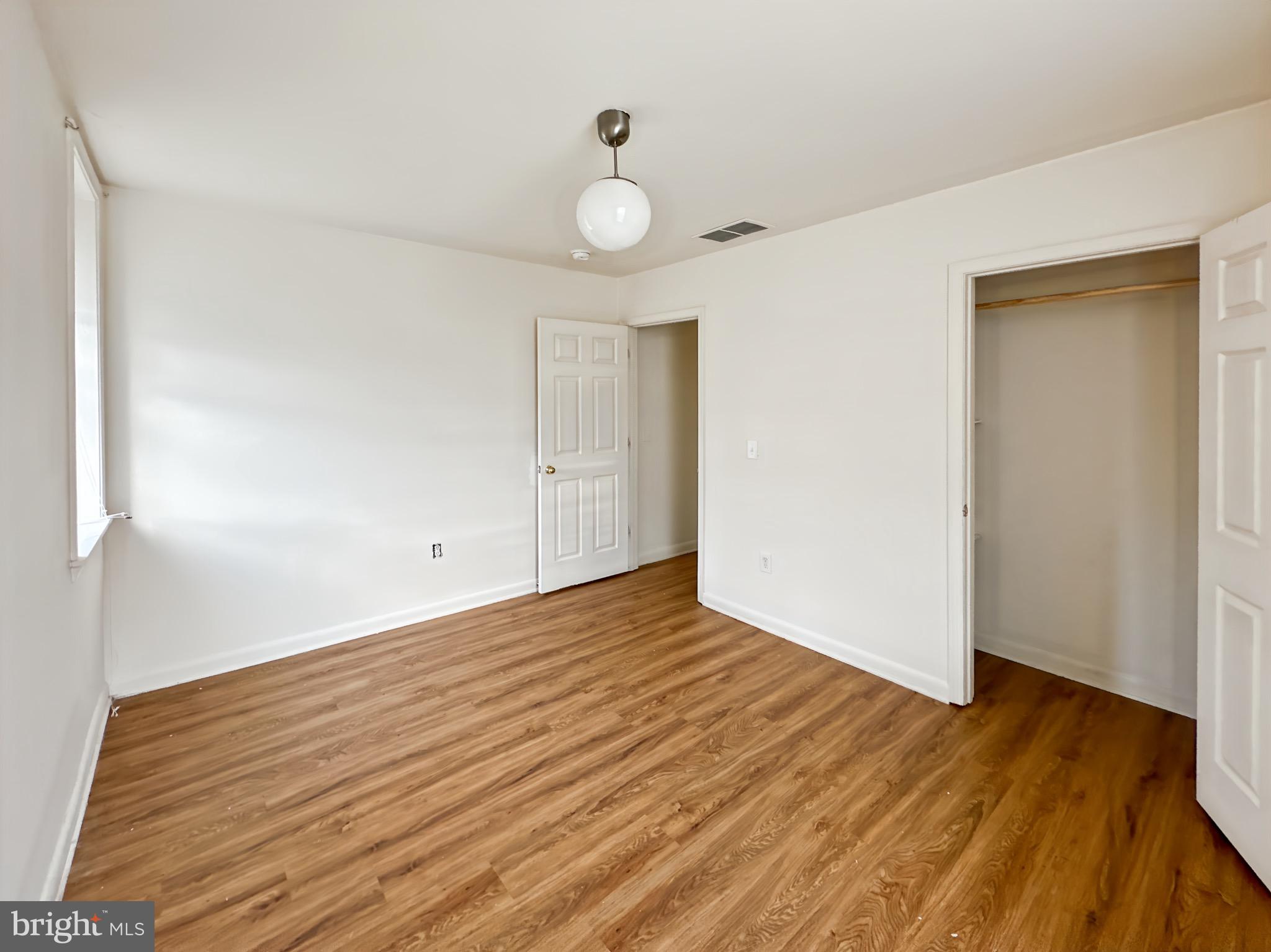 2426 Jefferson Street Baltimore, MD 21205 - Photo 17 of 17 a view of an empty room with wooden floor and a window