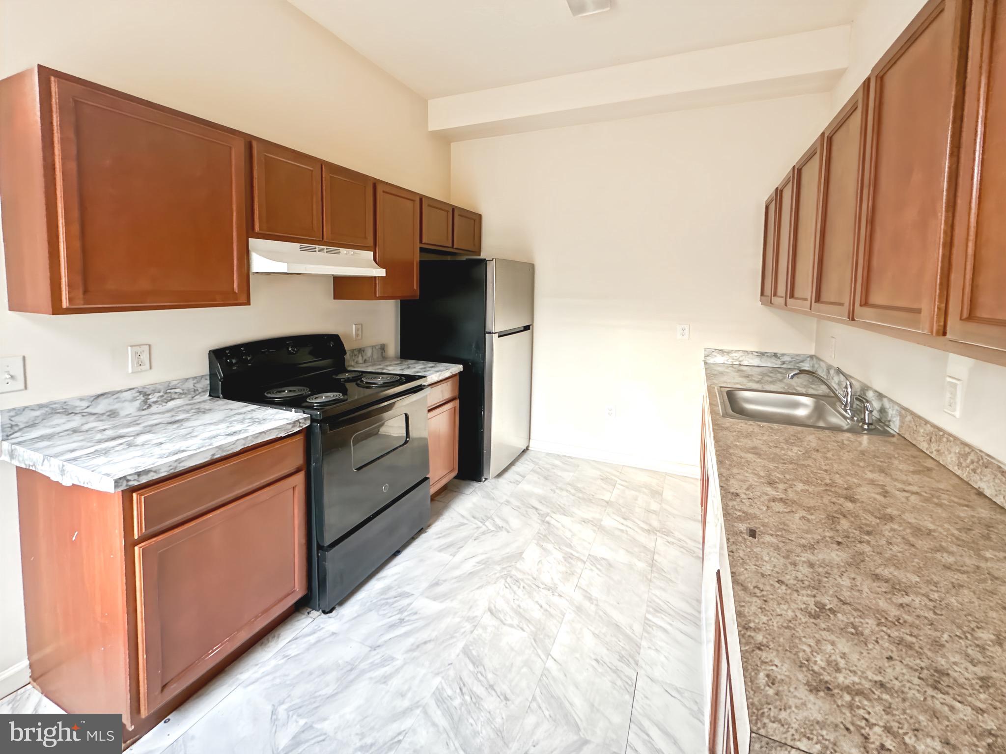 2426 Jefferson Street Baltimore, MD 21205 - Photo 9 of 17 a kitchen with stainless steel appliances granite countertop a stove a sink and a microwave