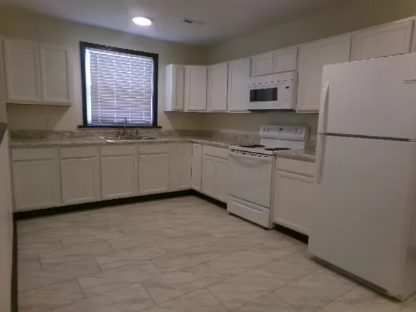 a kitchen with granite countertop cabinets stainless steel appliances and a sink