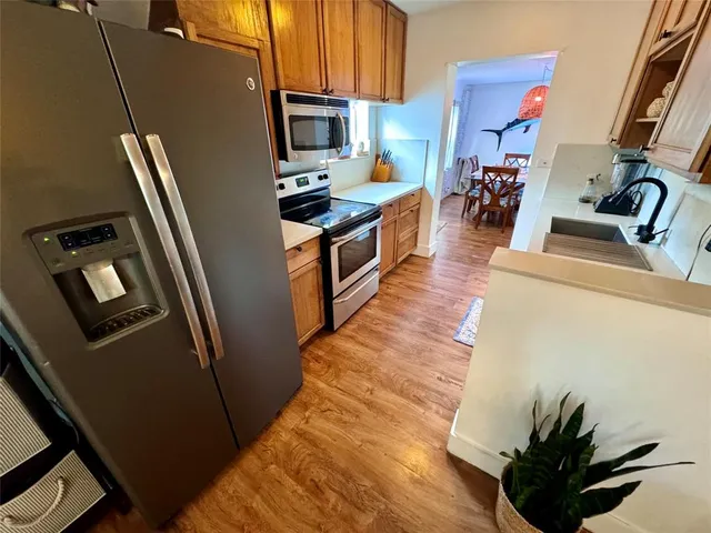 a kitchen with kitchen island a counter top space a sink a refrigerator and a stove