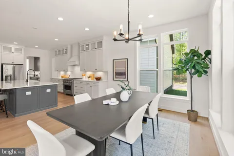 a dining room with furniture a chandelier and kitchen view