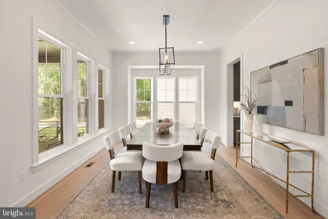 a dining room with furniture a chandelier and wooden floor