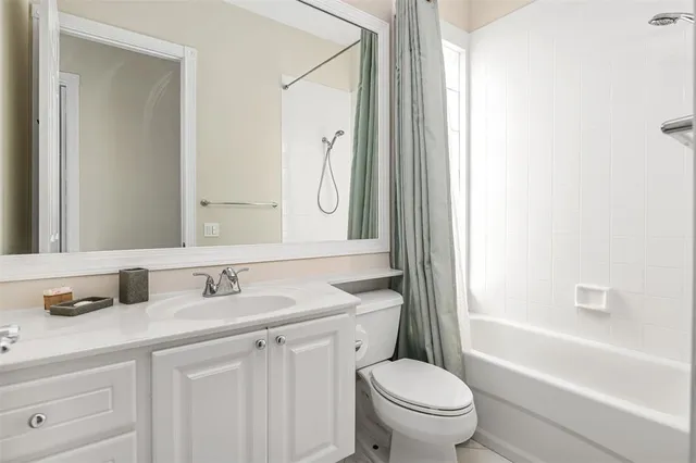 a bathroom with a granite countertop sink toilet a large mirror a bathtub and shower
