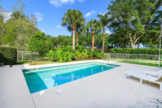 a view of backyard with swimming pool and outdoor seating