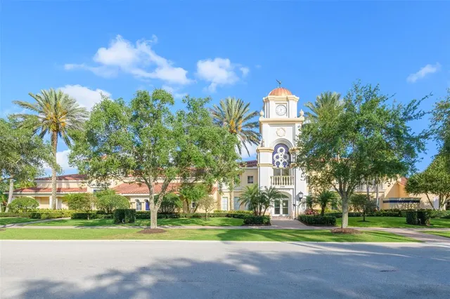a view of a building with a big yard and a large trees