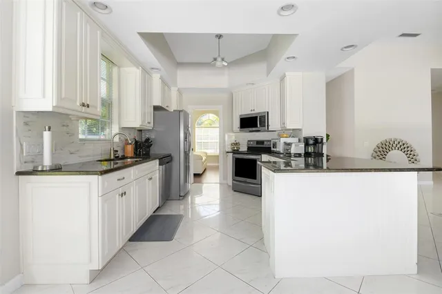 a kitchen with stainless steel appliances a refrigerator sink stove microwave and cabinets