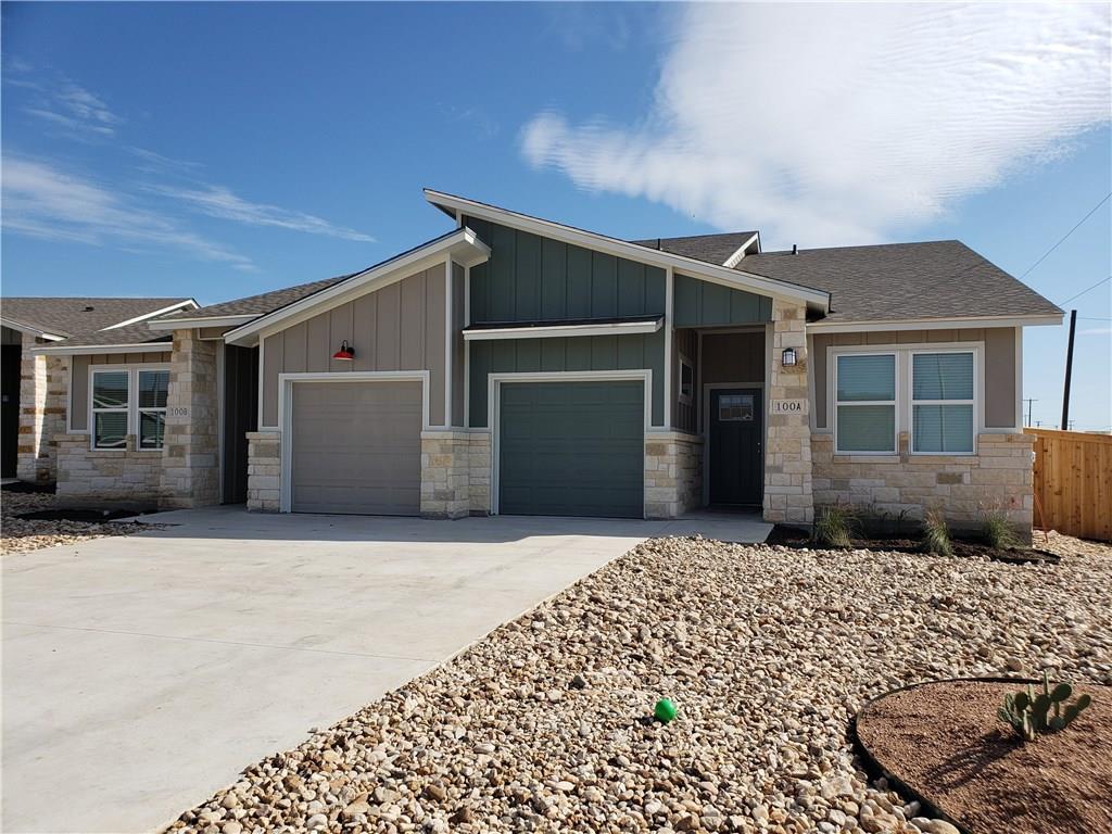View of front of home featuring board and batten siding, a garage, stone siding, concrete driveway, and a shingled roof