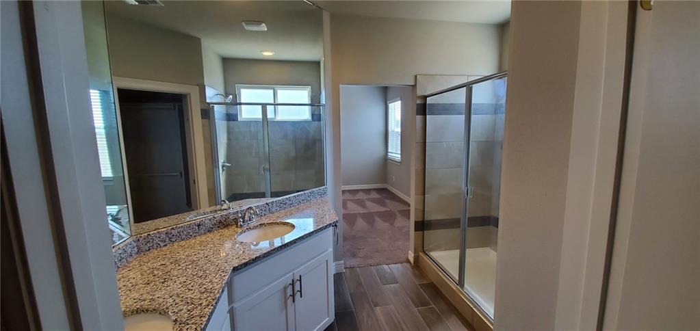 100 Bailey Kay Court, Unit B Jarrell, TX 76537 - Photo 6 of 14 Bathroom with double vanity, a stall shower, and wood finish floors