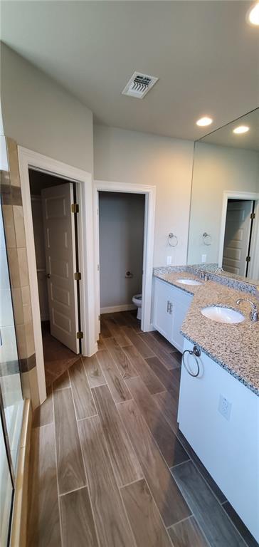 100 Bailey Kay Court, Unit B Jarrell, TX 76537 - Photo 7 of 14 Full bath featuring double vanity, wood finish floors, a tile shower, and recessed lighting