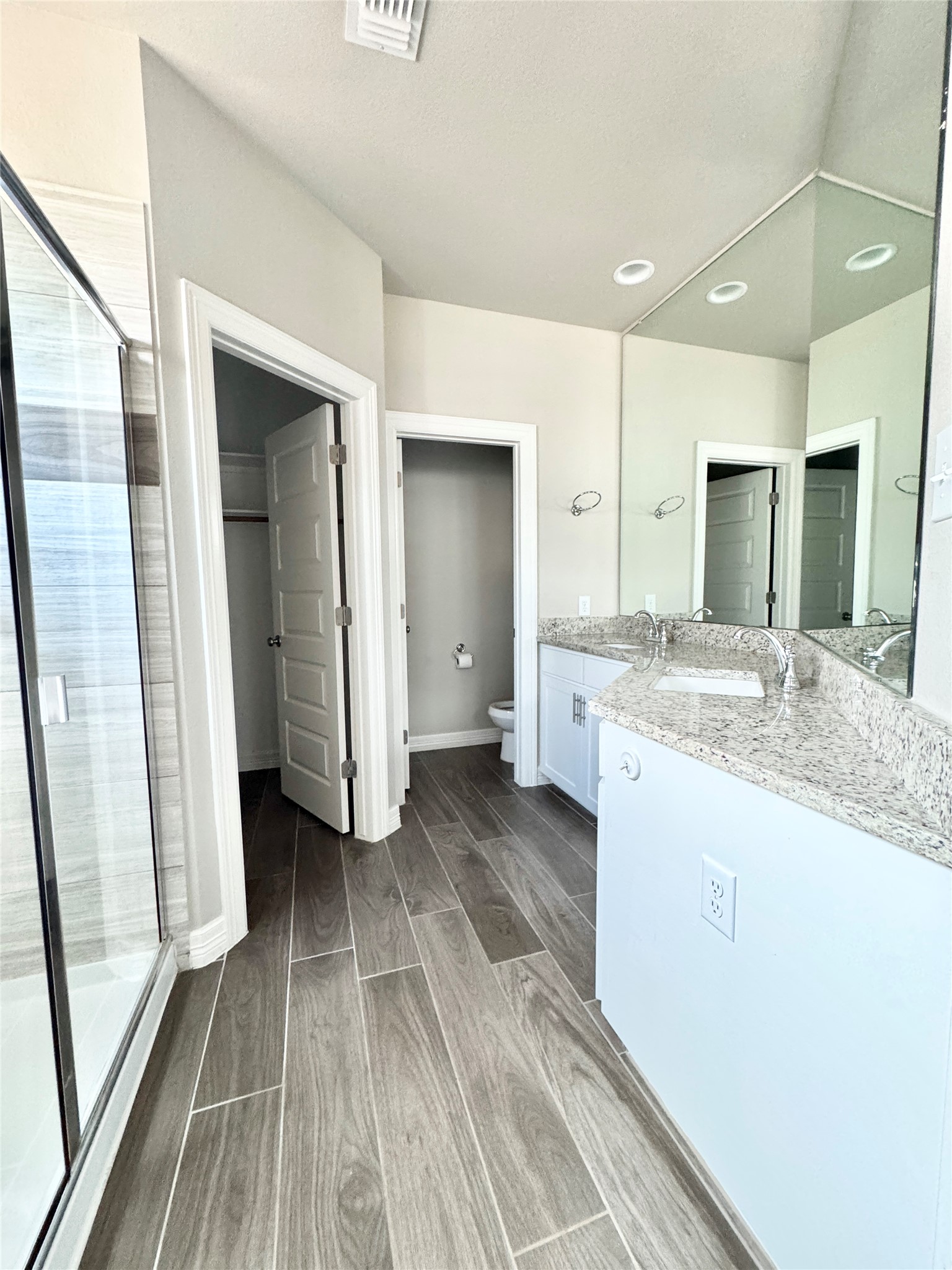 100 Bailey Kay Court, Unit B Jarrell, TX 76537 - Photo 10 of 14 Bathroom with vanity, wood finish floors, and a shower stall