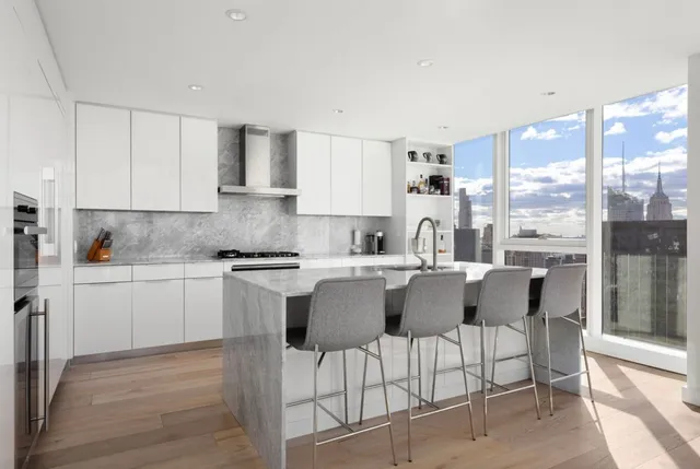 a kitchen with a dining table chairs and white cabinets