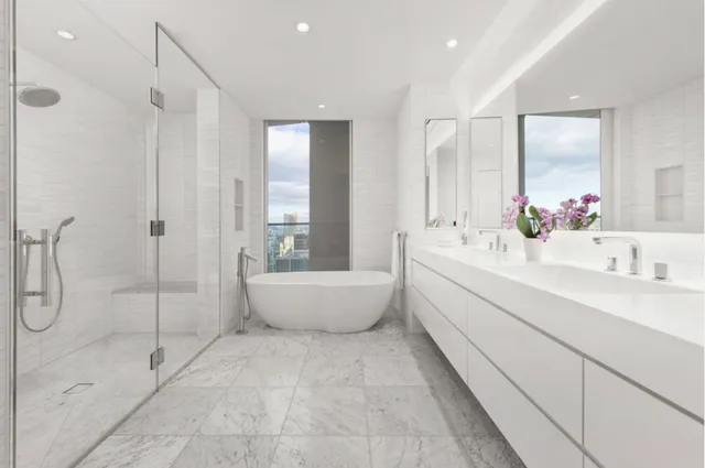 a bathroom with a tub sink shower and mirror