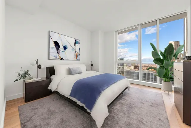 a spacious bedroom with a large bed and a large window