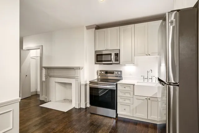 a kitchen with white cabinets and stainless steel appliances