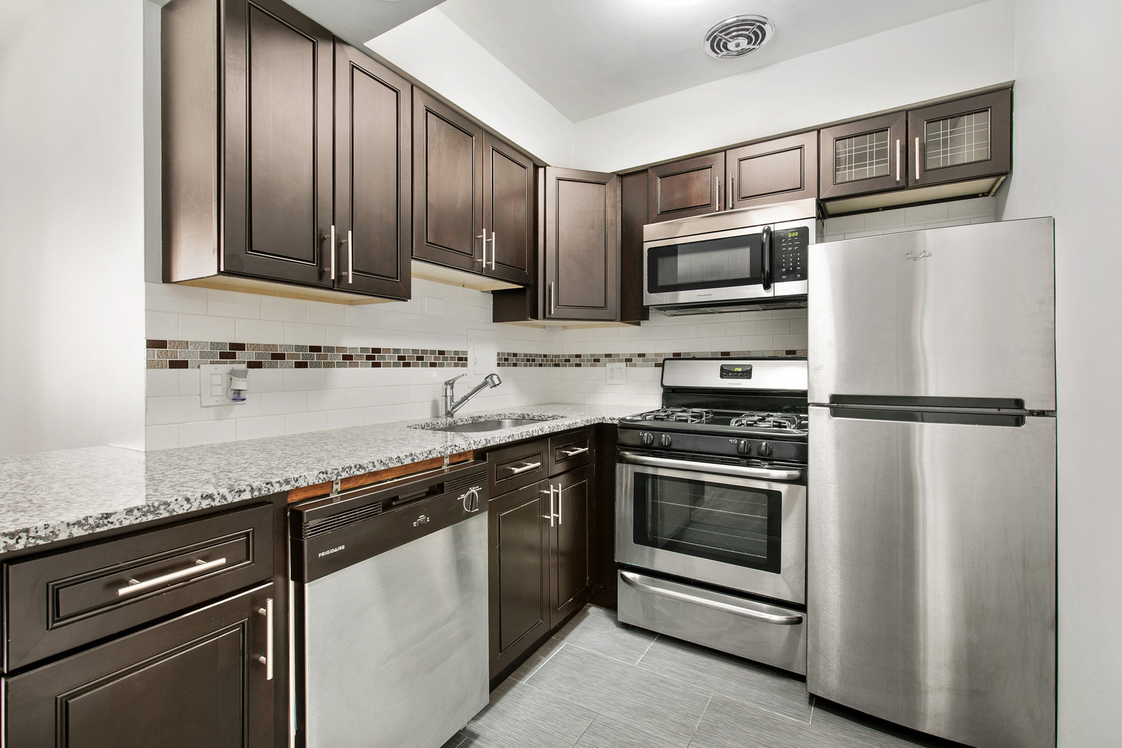 6201 North Kenmore Avenue, Unit 307 Chicago, IL 60660 - Photo 5 of 10 a kitchen with granite countertop stainless steel appliances and wooden cabinets