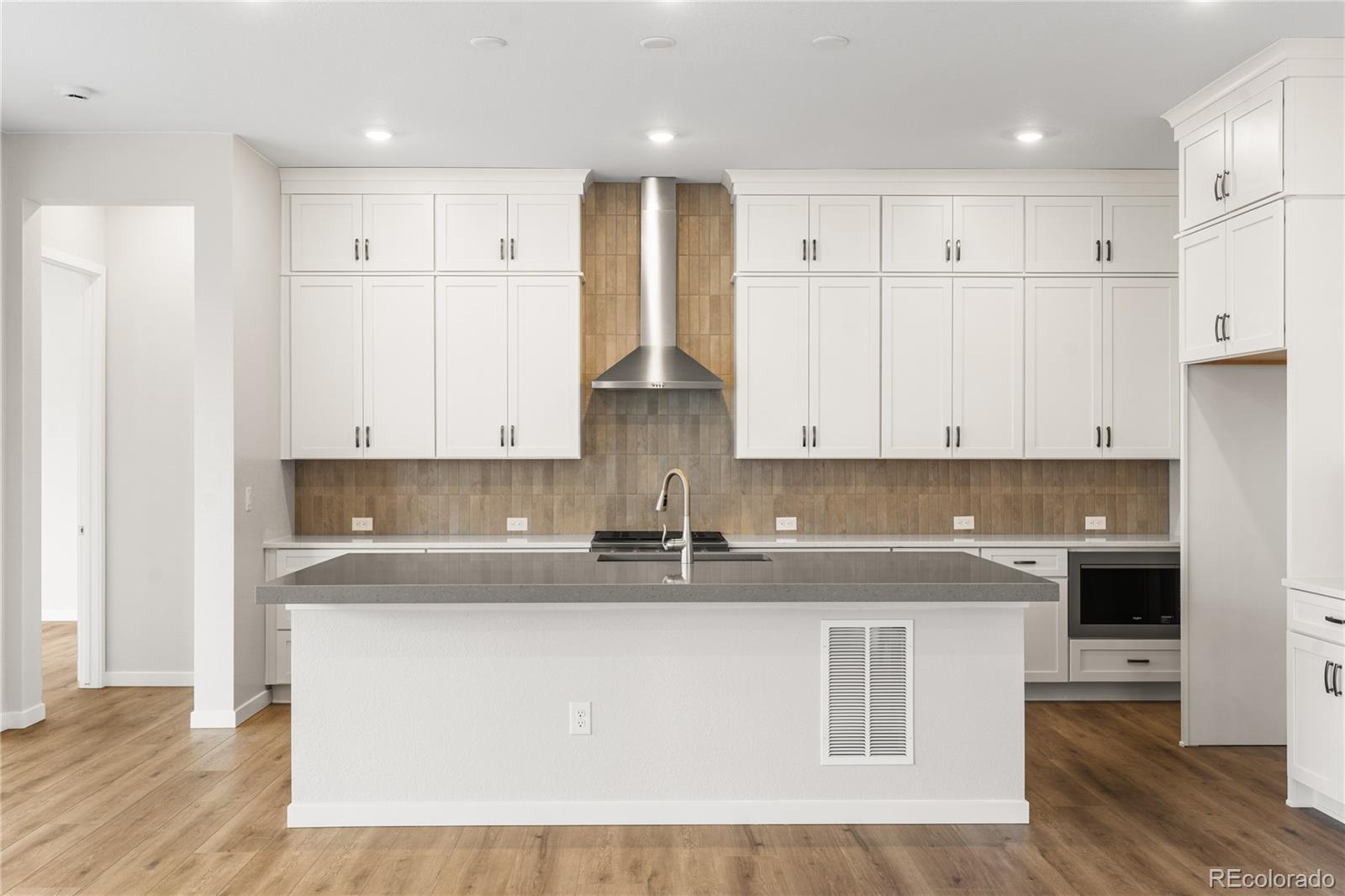 11116 Stonepath Street Littleton, CO 80125 - Photo 13 of 31 a kitchen with kitchen island granite countertop a sink a center island stainless steel appliances and cabinets