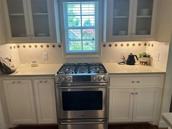 a stove top oven sitting inside of a kitchen