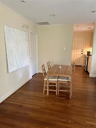 a view of a room with wooden floor table and chairs