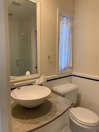 a bathroom with a sink and mirror with toilet