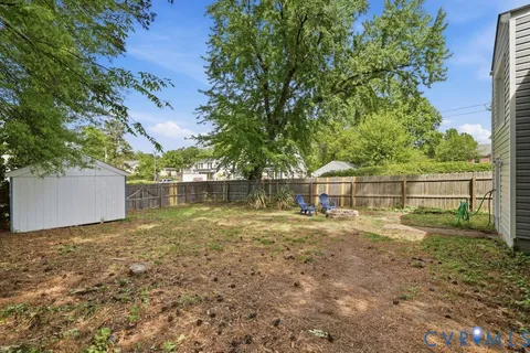 a view of a house with backyard and a tree