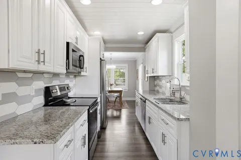 a kitchen with a sink window and cabinets