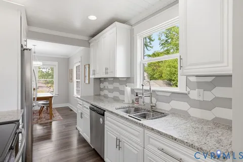 a kitchen with stainless steel appliances granite countertop a refrigerator a stove a sink and a microwave