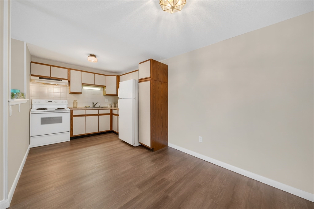 74 Beach Street, Unit 11 Woburn, MA 01801 - Photo 11 of 34 a kitchen with stainless steel appliances granite countertop a refrigerator and a stove top oven