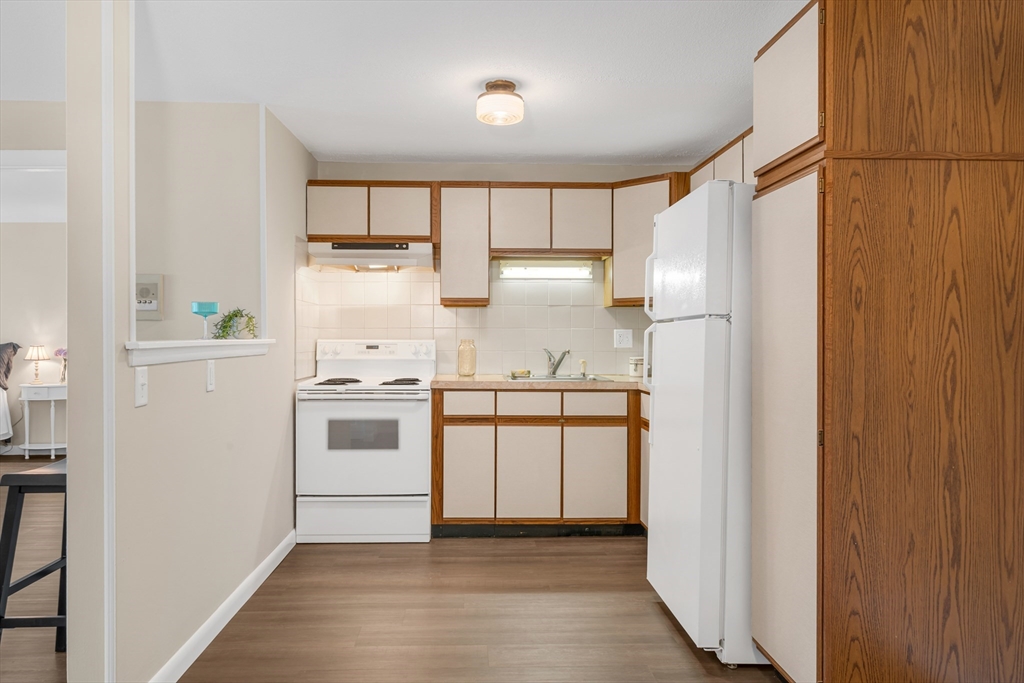 74 Beach Street, Unit 11 Woburn, MA 01801 - Photo 12 of 34 a kitchen with a refrigerator sink and cabinets