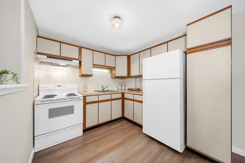 74 Beach Street, Unit 11 Woburn, MA 01801 - Photo 13 of 34 a kitchen with a refrigerator sink stove and cabinets