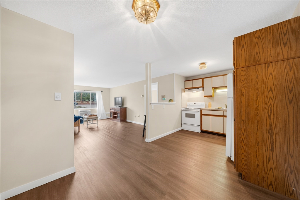 74 Beach Street, Unit 11 Woburn, MA 01801 - Photo 15 of 34 a view of a kitchen and dining room with wooden floor