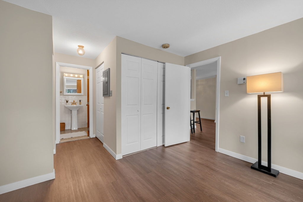74 Beach Street, Unit 11 Woburn, MA 01801 - Photo 23 of 34 an empty room with wooden floor and a lamp