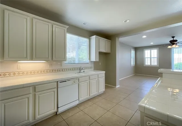 a view of a kitchen with kitchen island granite countertop a sink and dishwasher with a large window
