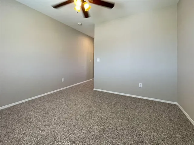 an empty room with a chandelier fan