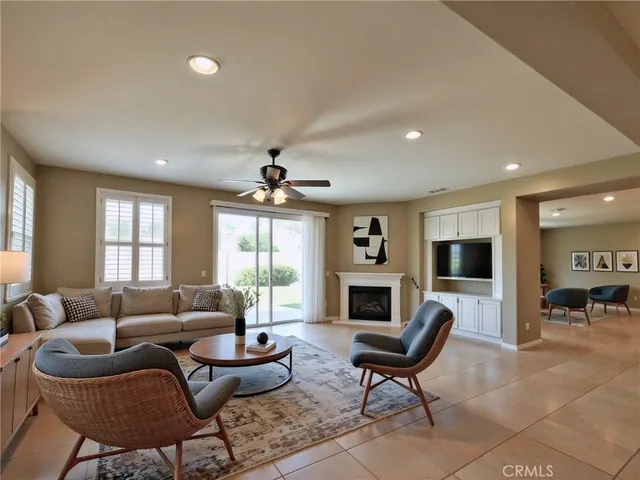a living room with furniture fireplace and a large window