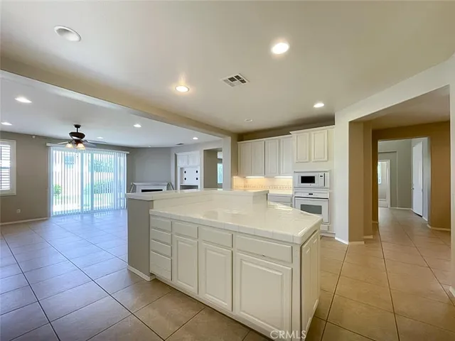 a large white kitchen with a sink and dishwasher