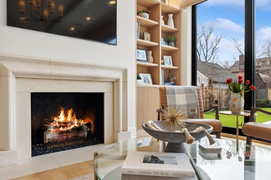 240 Raleigh Road Kenilworth, IL 60043 - Photo 16 of 71 a living room with furniture a fireplace and a flat screen tv