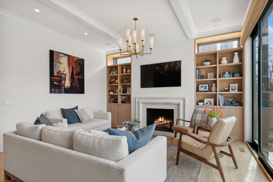 240 Raleigh Road Kenilworth, IL 60043 - Photo 18 of 71 a living room with furniture a fireplace and a flat screen tv