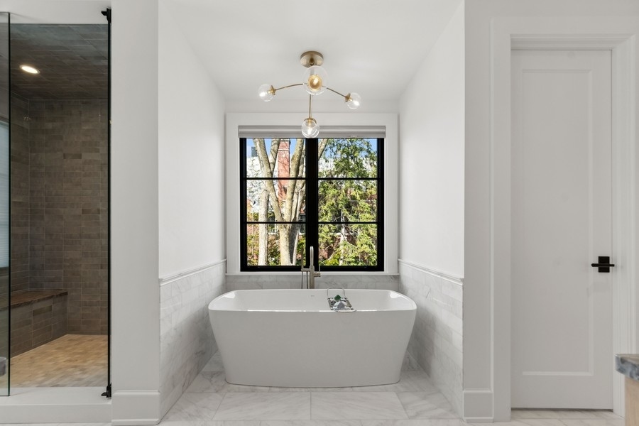 240 Raleigh Road Kenilworth, IL 60043 - Photo 38 of 71 a bathroom with a bathtub and windows