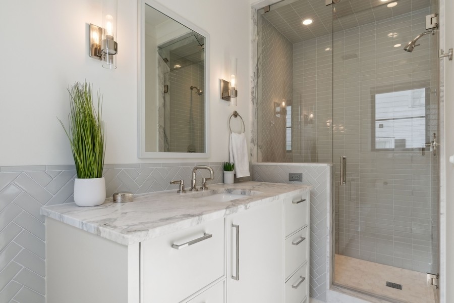 240 Raleigh Road Kenilworth, IL 60043 - Photo 45 of 71 a bathroom with a granite countertop sink a mirror and a shower