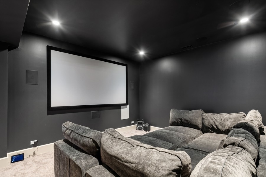 240 Raleigh Road Kenilworth, IL 60043 - Photo 57 of 71 a living room with couches and projector with a projector